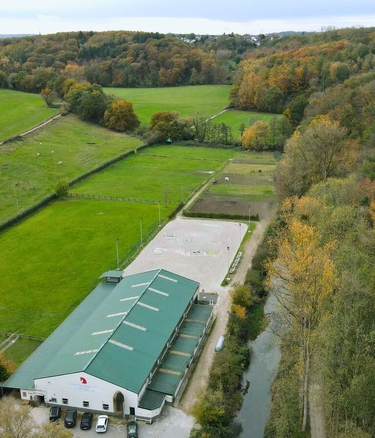 Reitstall Teuterhof in Würselen mit einer Drohne fotografiert. Der Reitstall, inkl. Außenreitplatz inmitten von Wald und Wiesen.
